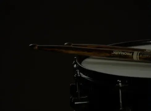 drum sticks resting on the head of a snare drum